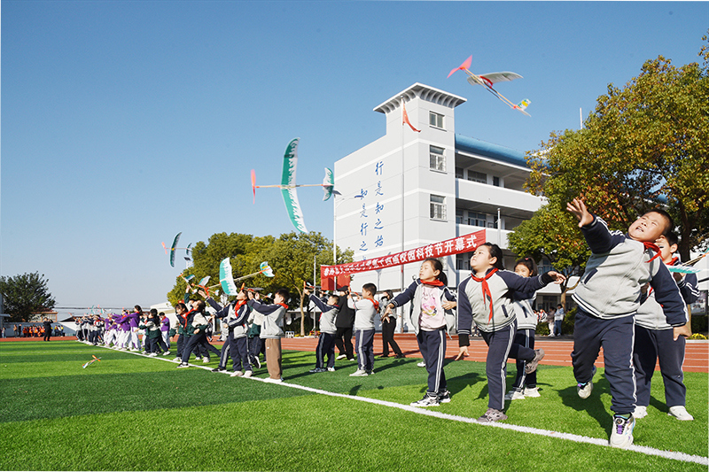 学校的孩子在校园科技节开幕式上放飞航模飞机