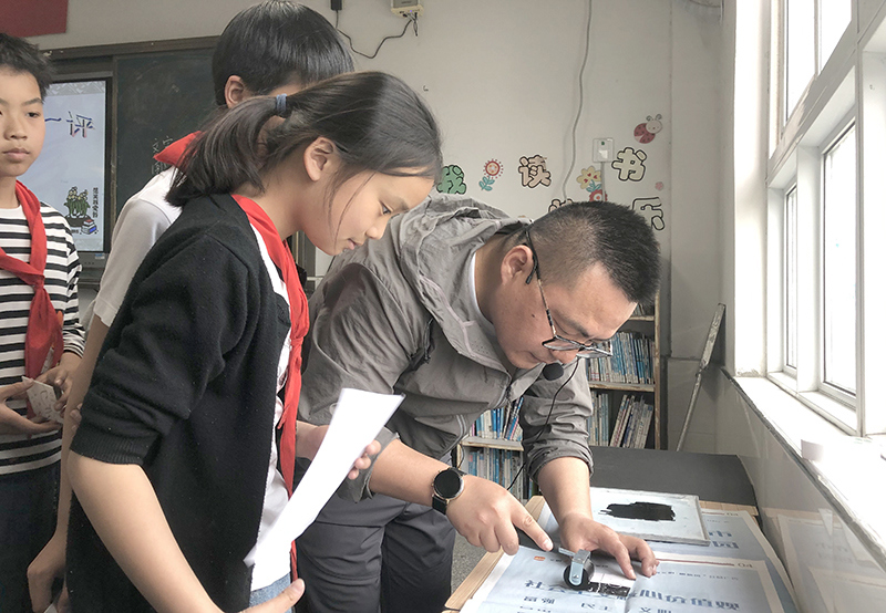 老师辅导孩子们印版画